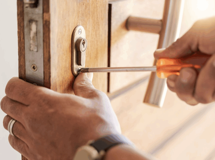 lose-up of an emergency locksmith’s hands repairing a front door lock.