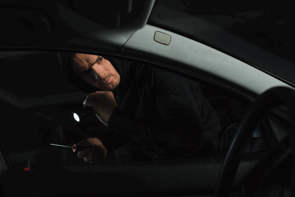 A driver searches for missing keys inside his car in the middle of the night using a flashlight.