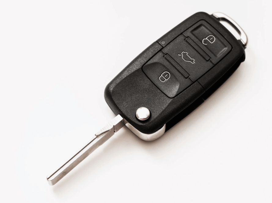 A close up shot of a black automotive car key replacement on a white background.